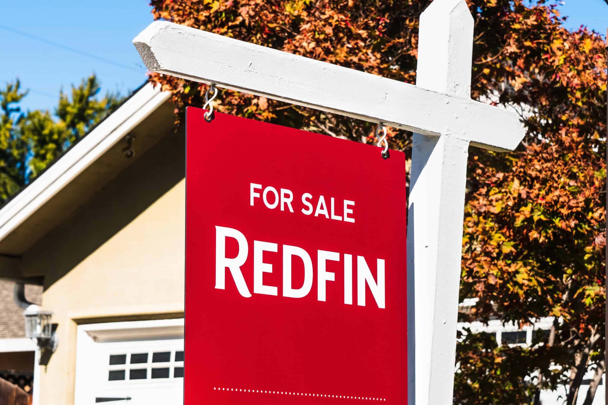 A Redfin "For Sale" sign in front of a home, symbolizing the impact of Rocket Companies' acquisition on the real estate market.