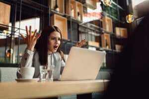 Frustrated homebuyer discovering unexpected closing cost issues on a laptop